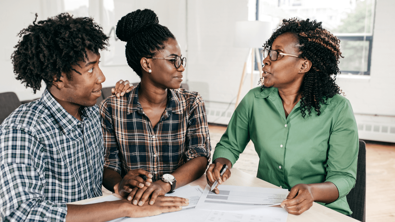 Advisor in green shirt explaining the mortgage market to a couple